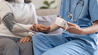 Nurse checking patient's blood pressure