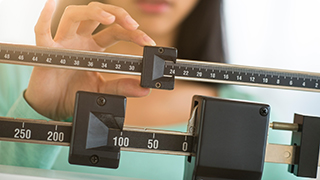 Woman weighing self on scale