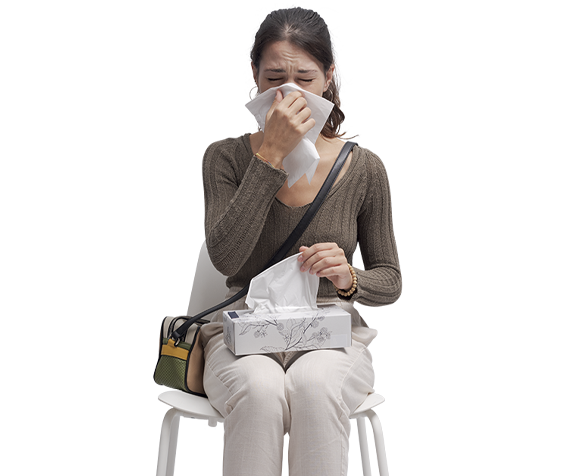 sick person sitting in chair with box of tissue